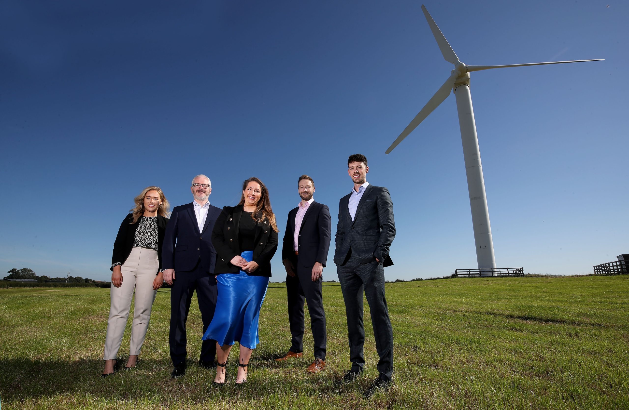 The Mills Selig Climate & Energy Team standing in front of a Wind Turbine